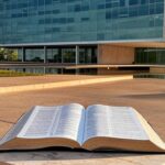 Edifício da CLDF em Brasília com Bíblia simbólica, ilustrando declaração de patrimônio e debate sobre laicidade estatal.