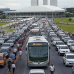 Ônibus de transporte público em avenida de Brasília com Congresso ao fundo, representando lei de transparência em custos no DF com falhas.
