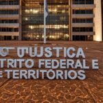 Edifício do TJDFT em Brasília com bandeira a meio mastro, simbolizando luto pela morte de desembargador.