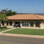 Fachada de escola pública moderna inaugurada pelo GDF no Jardins Mangueiral, Brasília, para 1,2 mil alunos.