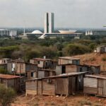 Bairro com casas precárias em Recanto das Emas, expondo déficit habitacional no DF, em contraste com skyline de Brasília.