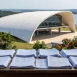 Prédio da Caesb em Brasília com pilhas de documentos representando burocracia em inscrições para conselho no DF.