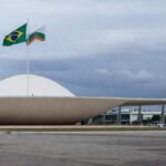 Viatura da Polícia Militar do DF em frente à CLDF em Brasília, destacando falhas na reintegração de policiais e impunidade na violência contra mulheres.