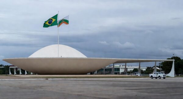 Viatura da Polícia Militar do DF em frente à CLDF em Brasília, destacando falhas na reintegração de policiais e impunidade na violência contra mulheres.