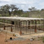 Canteiro de obras com laje caída após acidente no Gama, DF, em estilo fotojornalístico realista.