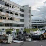 Hospital em Brasília com ambulâncias e viaturas policiais, representando colapso na saúde e insegurança no Distrito Federal.