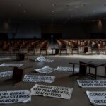 Fachada da CLDF em Brasília com banners de fitas zebra para o Dia das Doenças Raras, expondo falhas no apoio a pacientes.