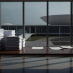 Tubulação de saneamento quebrada vazando água suja em rua de Brasília, simbolizando falhas na Caesb e exclusão digital em inscrições de estágios.