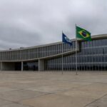 Edifício da Câmara Legislativa do DF em Brasília, com bandeiras, representando homenagem polêmica ignorando crises.