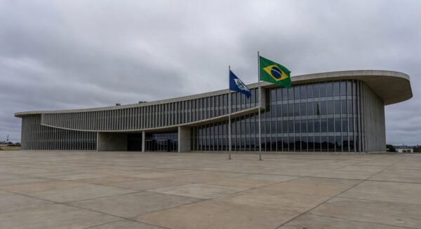 Edifício da Câmara Legislativa do DF em Brasília, com bandeiras, representando homenagem polêmica ignorando crises.