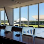 Sala de conferências em Brasília com elementos digitais representando seminário sobre desafios do ECA Digital.