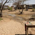 Reservatório seco em Brasília durante crise hídrica no DF, ofuscando entrega de medalhas pela Caesb no Dia Mundial da Água.