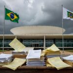 Edifício da CLDF em Brasília com nuvens escuras, representando aprovação de PL que ameaça equilíbrio fiscal.