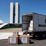 Caixas de vacinas contra Covid-19 em centro de distribuição em Brasília, representando nova remessa do Ministério da Saúde.