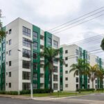 Vista de condomínio residencial no Jardim Botânico, Brasília, com postes de energia indicando interrupção programada.