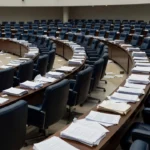 Plenário da CLDF em Brasília com documentos orçamentários representando falha na fiscalização